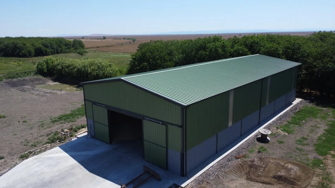 Agricultural building with green cladding and access from a concrete yard