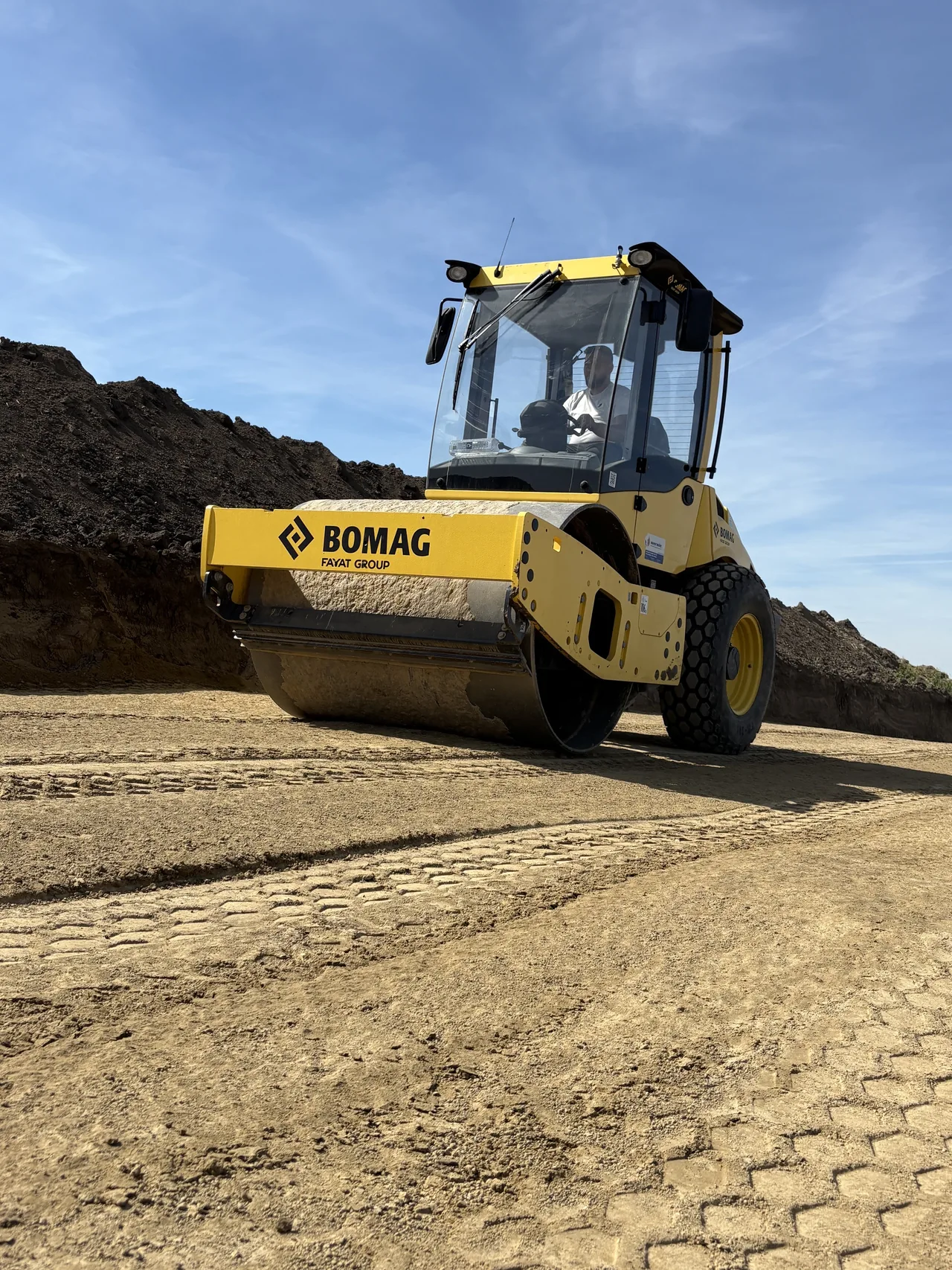 Cilindru compactor Bomag cu operator, lucrând pe un șantier Beavers