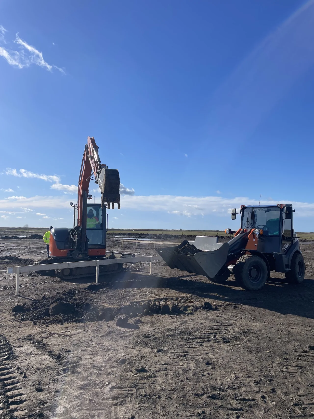 Miniexcavator și încărcător compact Beavers executând lucrări la o fundație