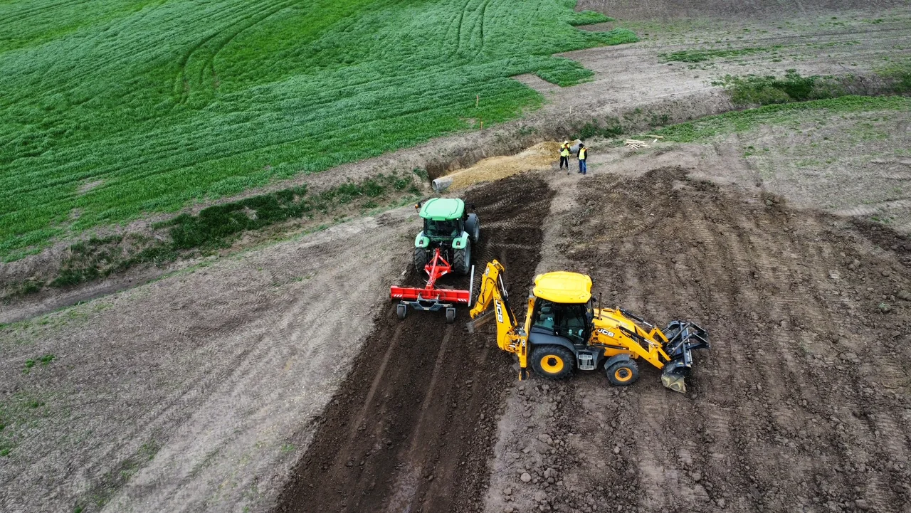 Tractor cu echipament de nivelare și buldoexcavator pe un amplasament Beavers